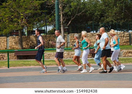 Eight people jogging in the park on a beautiful day