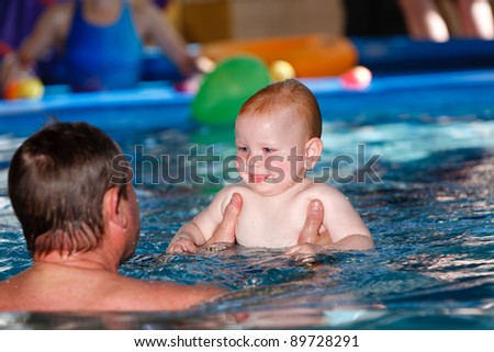 Father and son bathing in the pool