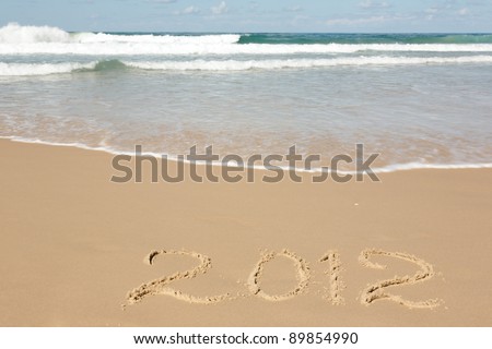 Handwritten message for year 2012 on deserted beach leaves room in clean sand