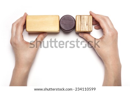 A female hand hold(pick up) the various wood blocks isolated white, top view at the studio.