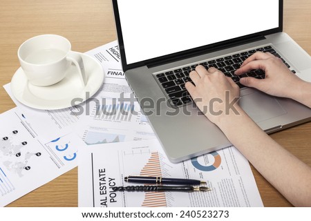A working wooden desk(table) with notebook computer, coffee cup, paper, pencil and hand.