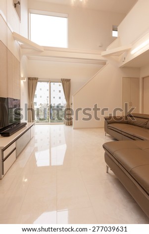 a brown leather sofa at the white living room on the marble bottom and LCD(internet) TV, piano double layered house with stair to second floor.