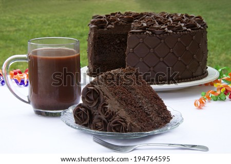 A slice of Chocolate cake with chocolate cream filling topped with handmade chocolate frosting roses