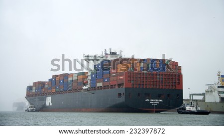 OAKLAND, CA - NOVEMBER 22, 2014: Tug Boats Z-FIVE and SANDRA HUGH guide an American President Lines (APL) Container ship loaded with Shipping Containers out of the Port of Oakland despite fog and rain