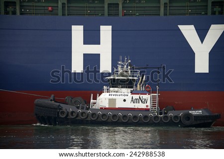 OAKLAND, CA - JANUARY 08, 2015: REVOLUTION providing Ship Assist at the Port of Oakland. Large ships can\'t navigate through a crowded port easier. Tug boat assist decreases the chance of collisions.