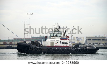 OAKLAND, CA - JANUARY 08, 2015: SANDRA HUGH providing Ship Assist at the Port of Oakland. Large ships can\'t navigate through a crowded port easier. Tug boat assist decreases the chance of collisions.