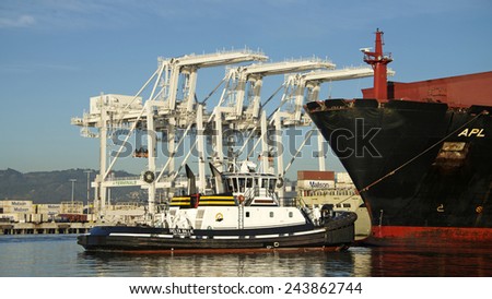 OAKLAND, CA - JANUARY 12, 2015: American President Lines Ltd. (APL) Cargo Ship KOREA entering the Port of Oakland with Tugboat DELTA BILLIE pulling from the bow of the ship.