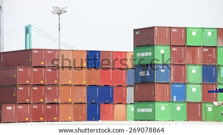 SAN PEDRO, CA - APRIL 10, 2015: Brightly colored shipping containers stacked on the docks at the Port of Los Angeles. Containers are organized and placed algorithmically for efficient transport.
