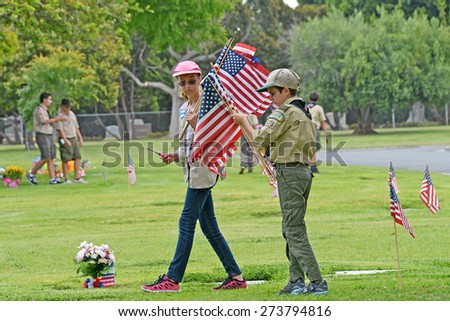 SANTA ANA, CA - MAY 25, 2013:  Boy Scouts and Girl Scouts of Orange County place flags next to the graves of veterans in preparation for Memorial Day services at Fairhaven Memorial Park and Mortuary.