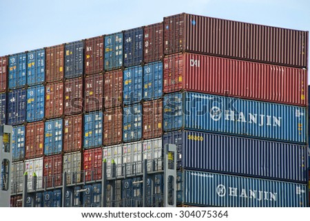 OAKLAND, CA - AUGUST 05, 2015: Over 90 percent of the world\'s trade is carried by sea. Shipping Containers stacked on a cargo ship, organized and placed algorithmically for efficient transport.