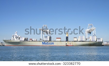 OAKLAND, CA - SEPTEMBER 21, 2015: Pilot Vessel GOLDEN GATE picking up from Matson Cargo Ship MANOA. An experience pilot is critical for guiding the huge ships in and out of the Port of Oakland.