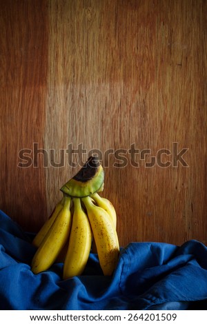 bunch of banana put on old wood table, still life image dark tone
