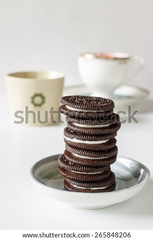 Udonthani-Thailand April 2, 2015 : Chocolate cookies with cream served in small plate with coffee time or tea time put on vintage white background, image soft tone