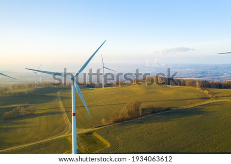 Panoramic view of wind farm or wind park, with high wind turbines for generation electricity with copy space. Green energy concept.