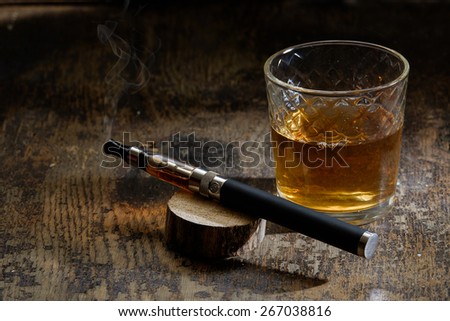 vintage still life with e-cigarette and a glass of bourbon table