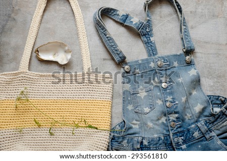Outfit of casual woman. Denim overall with a summer female white yellow bag on a wooden background