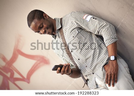Young black man checking messages on his smart phone