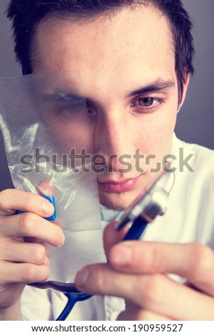 Doctor looking at his stethoscope with an eye covered by a resuscitation mask