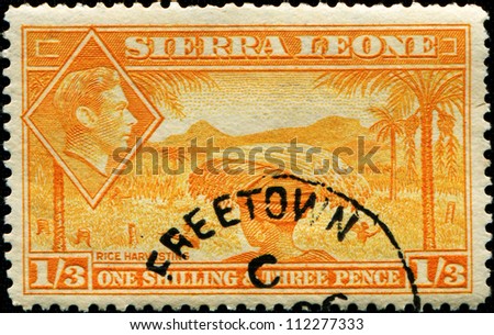 SIERRA LEONE - CIRCA 1940: A  stamp printed in Sierra Leone shows native of country rice harvesting and inset of King George VI, circa 1940