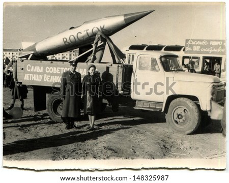 USSR - CIRCA 7 November 1967: Vintage photo shows Soviet Air Force pilot and his wife and missile East mounted on truck, demonstration marking 50th anniversary of Great October Socialist Revolution