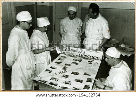 UKRAINE - CIRCA 1964: An antique photo shows Cancer clinic staff to discuss material wall newspaper Soviet oncologist Voroshilovgrad, now Lugansk, 1964