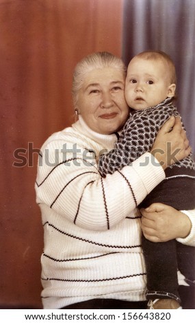ORSK - CIRCA 1992: studio photography grandmother with her grandson, Orsk, Soviet Union, December, 1992 Name of boy is Nikolay, 2  years old.