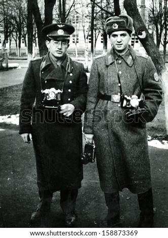 KUBINKA - 1977: Two young man in military uniform with cameras, Kubinka air base, Moscow Military District, USSR, 1977