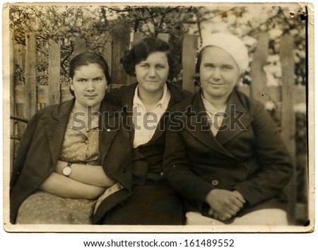 USSR - CIRCA 1939: three women sitting near the fence, behind which blooms garden, Mineralnye Vody, the Caucasus, USSR, May 1, 1939