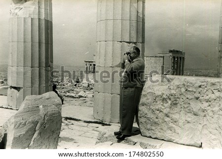 GREECE, ATHENS -  CIRCA 1950s: An antique photo shows fat man photographed at Parthenon, Acropolis ruin