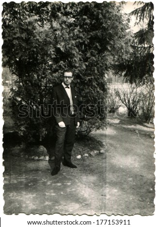 GERMANY - April 30, 1962: An antique photo of man in bisiness suit posing in the park