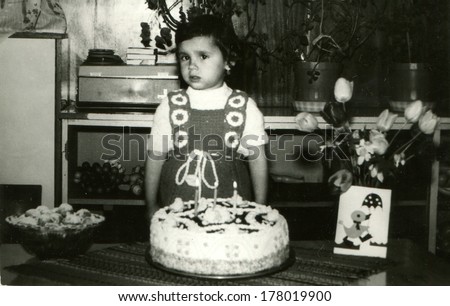 BULGARIA - APRIL 1, 1984:  girl on her birthday, the village Vodice, community Popovo, Targovishte region, Bulgaria, April 1, 1984. Name od girl is Tanya, 3 years old