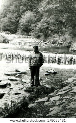 GERMANY - 1960s: An antique photo shows man on a rock on a background of the river rapids
