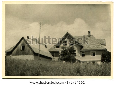 GERMANY - CIRCA 1960s: An antique photo of three-storey private house with a tiled roof