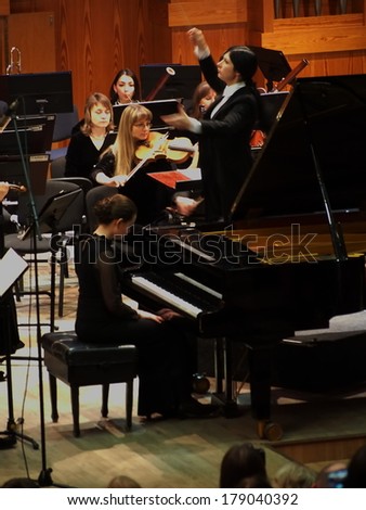UKRAINE, LUGANSK - FEBRUARY 27,  2014:Lugansk Philharmonic Orchestra performed the Concerto No1 for piano and orchestra by Camille Saint-Saens. Conductor is Catherine Osadchaya, soloist - Irina Burgan.