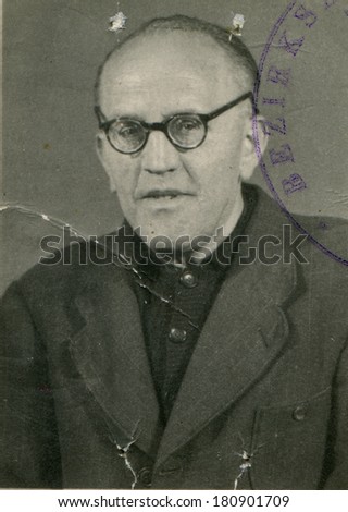 GERMANY - CIRCA 1930s: An antique photo of studio portrait of a bald middle-aged man in a suit and glasses