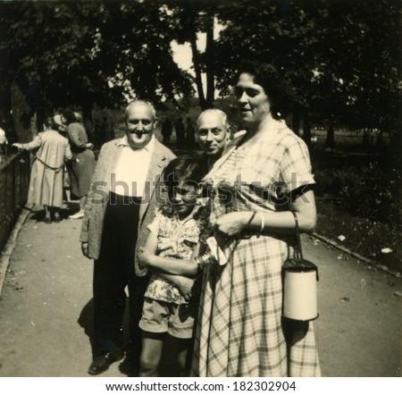 GERMANY, GRANSEE - CIRCA 1950s: An antique photo of woman, a small boy and two older men posing on the path in the park