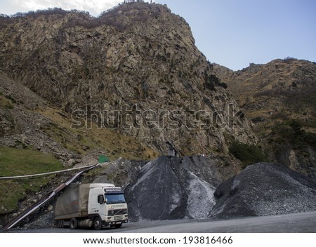 KAZBEGI, GEORGIA - April 29,  2014: Truck stay under mountain near Check point Kazbegi in Darial Gorge on Georgian Military Road