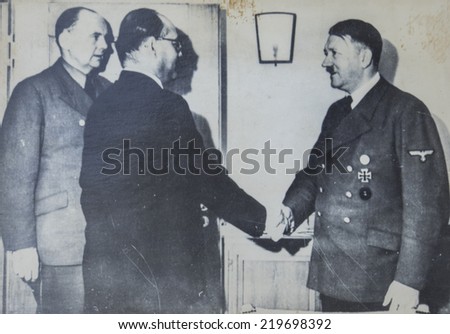 GERMANY - CIRCA 1940s: Adolf Hitler shakes hands with one of the man during an official meeting. Antique photograph.