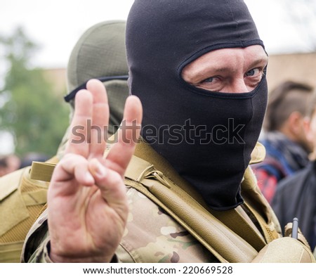 UKRAINE, KYIV - September 30, 2014: Soldier raises three fingers in greeting as a symbol of the Ukrainian National Emblem