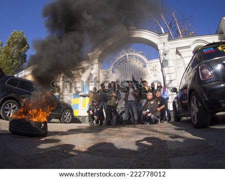 KIEV , UKRAINE - October 10, 2014: Activists posing with a burning tire near the gate of the residence. -- Avtomaydan noisy and smoky picketed the residence of the President of Ukraine.