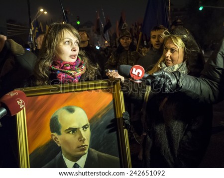 KIEV, UKRAINE - January 1, 2015: LifeNews journalist Zhanna Karpenko (R) interviews marchers. Police detained a suspect in attack on journalists during a torch procession in honor of Stepan Bandera.