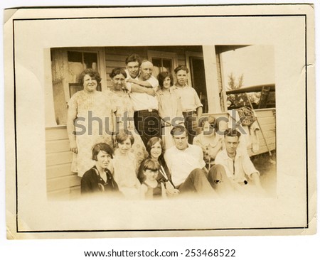 USA - CIRCA 1930s: Reproduction of an antique photo shows large farming family for several generations, posing against the backdrop of the rural house