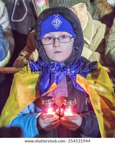 KIEV, UKRAINE - February 20, 2015: Boy hold lighted lamp -- At the Independence Square in Kiev gathered residents and visitors to participate in activities commemorating the heroes of Heaven in honor