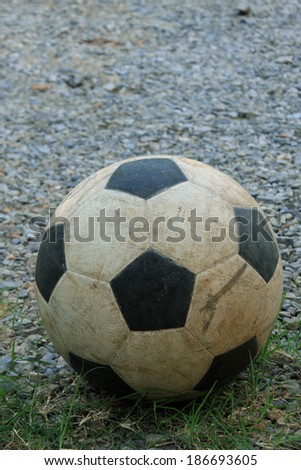 An old football on crushed gravel yard