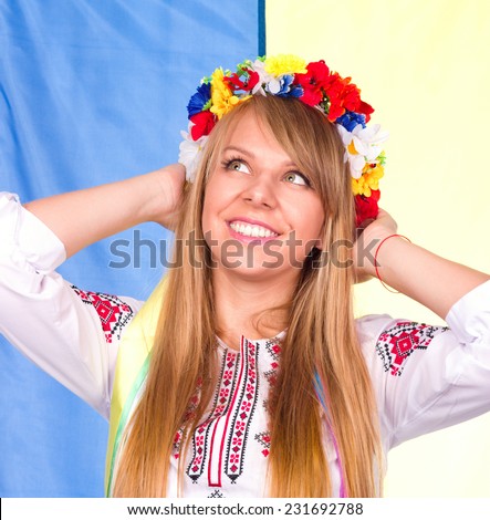 Happy cute girl in the Ukrainian national costume and Ukrainian flag