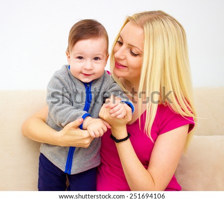 people, family, motherhood and children concept - happy mother hugging adorable baby