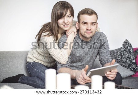 Couple sitting on sofa and surfing the net
