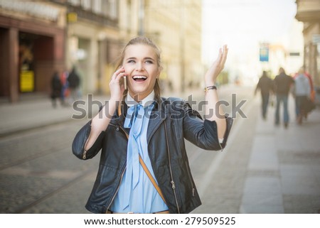 Happy woman receiving good news on the phone in city center