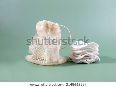 Cotton reusable make-up remover pads in a cloth bag on a green background. The concept of ecology and conscious consumption. Reusable cotton pads. Foto stock © 