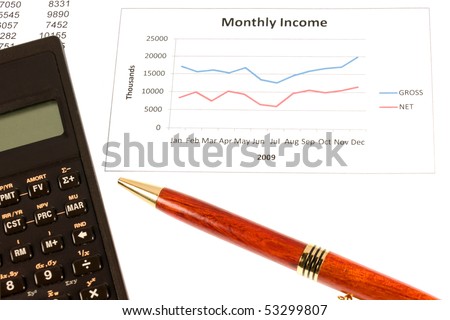 A line graph showing a profitable year with a calculator and pen in the shot.  Might be used as a small business conceptual image depicting profit and success